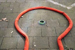 Eine orangefarbene mobile Minigolfbahn auf dem Boden mit einer grünen Mitte.