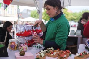 Artist Paula Erstmann scoops sweets into a bag at the mobile sweets stand Snail Kiosk.