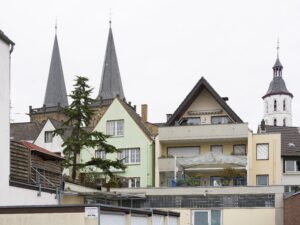 Historische Altstadt Xantens mit Häusern unterschiedlicher Baustile und zwei Kirchtürmen.