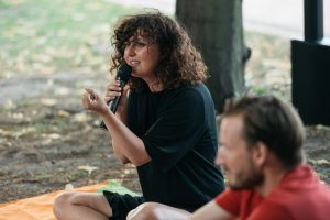 Meral Kureyshi spricht bei einer Lesung im Solebad Werne und hält ein Mikrofon.