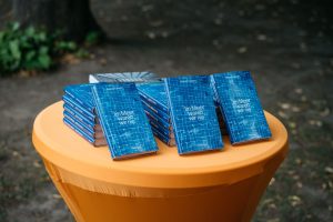 Stapel des Romans „Im Meer waren wir nie“ von Meral Kureyshi auf einem Tisch im Parkbereich des Solebads.