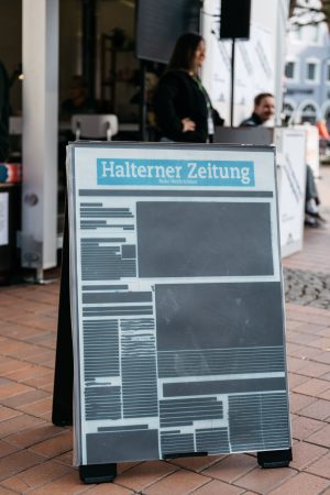 Geschwärzte Zeitungsseite aus Local Blackout von Lütfiye Güzel, hier die „Halterner Zeitung“, auf einem Aufsteller im öffentlichen Raum.