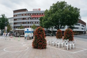 The open course of the Hammer Caretaker Championships is set up on Willy-Brandt-Platz, with markings, equipment, and white chairs.