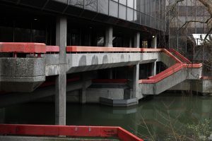 Photograph by Fatih Kurçeren: A concrete structure with red railings and stairways stands above a basin of water.