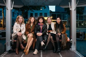 Esra Canpalat sits with four other women in a group portrait on the trailer stage.