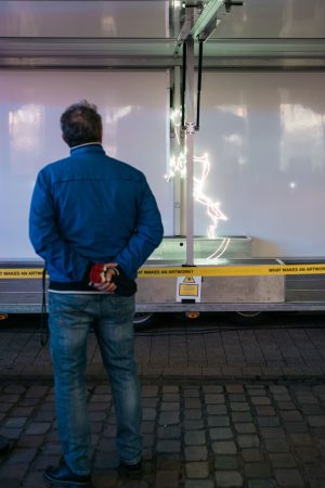 Eine Person betrachtet aus der Nähe die Lichtinstallation von Paul Spengemann im Trailer.