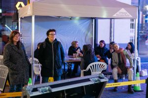 Menschen sitzen und stehen bei der Grand Snail Tour unter einem Pavillon von Urbane Künste Ruhr.