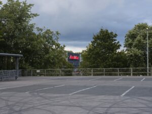 Asphaltboden, soweit das Auge reicht: Die „Autolesung“ der Autorin Tunay Önder findet auf dem brachial-charmanten MediaMarkt-Parkplatz in Marl statt.